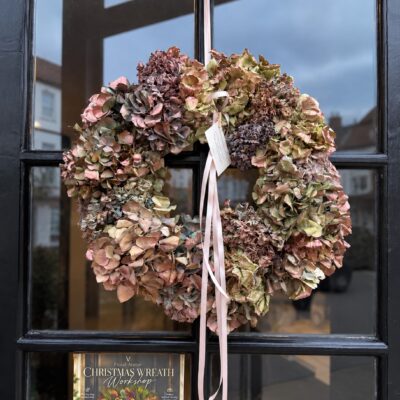 Handmade dried hydrangea wreath in dusky pink, mauve and green with pale ribbons